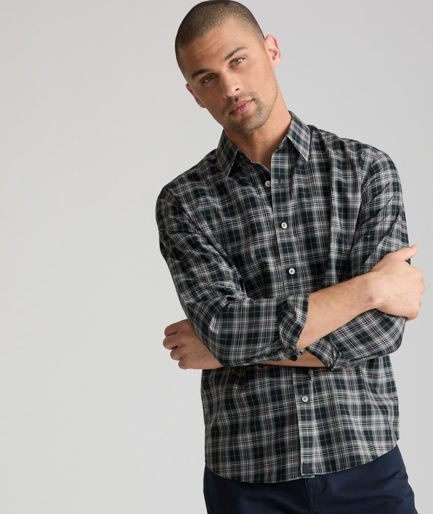 Model is wearing UNTUCKit Wrinkle-Free Devitt Shirt in Black Grounded Multi Plaid. 