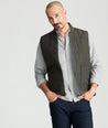 Model is wearing UNTUCKit Harper vest in dark gray/green.. 