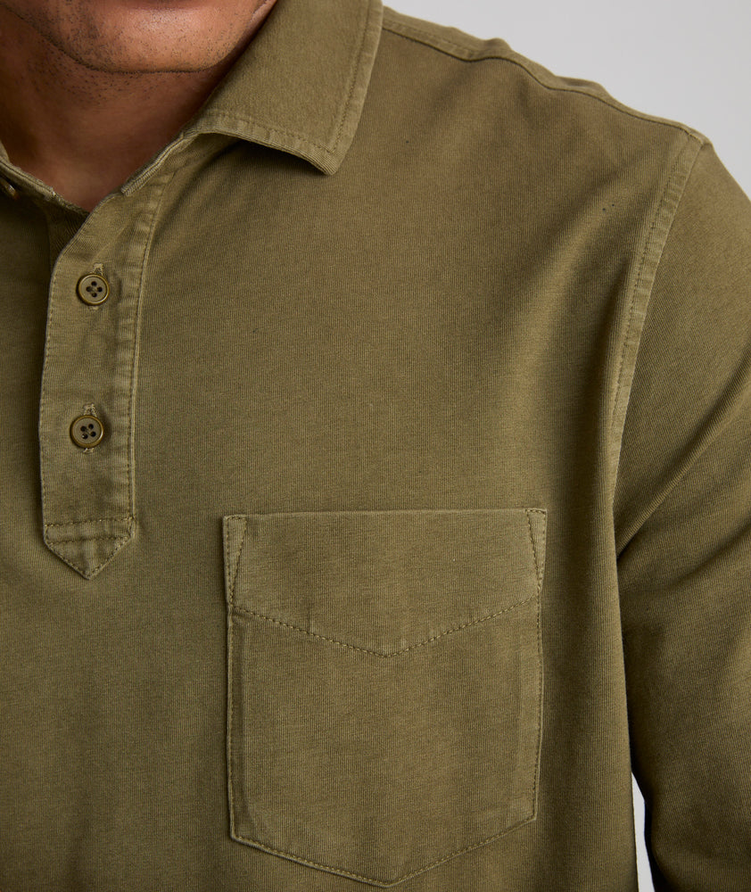 Model is wearing UNTUCKit Mays garment dyed long sleeve polo in dark olive. 