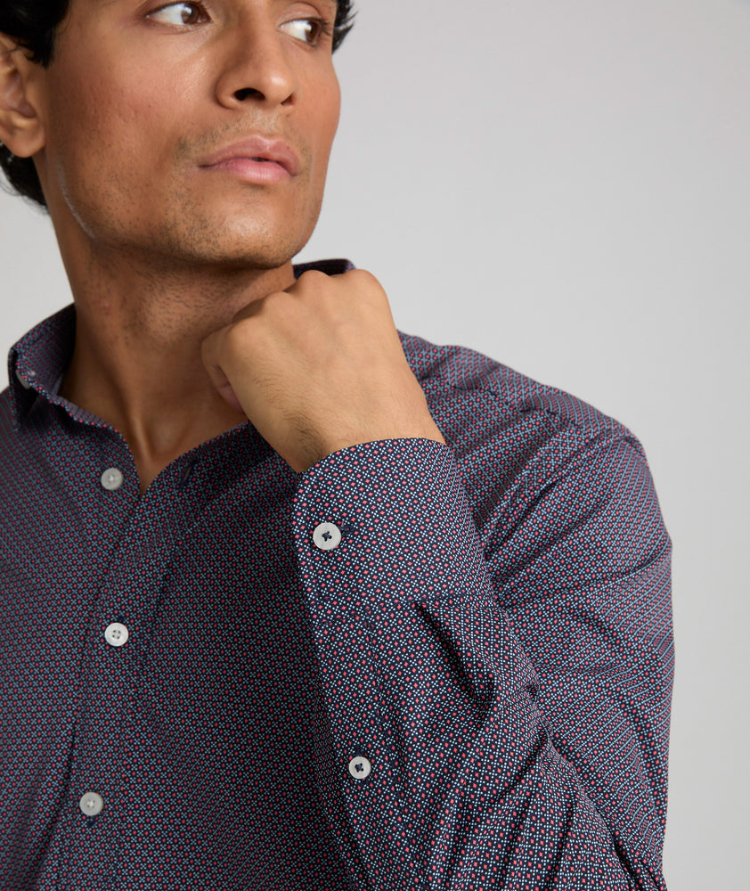 Model is wearing UNTUCKit Wrinkle-Free Performance Peraldi Shirt in Navy & Red Micro Print.