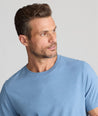 Model is wearing UNTUCKit saxum Ultra Soft tee in soft blue. 